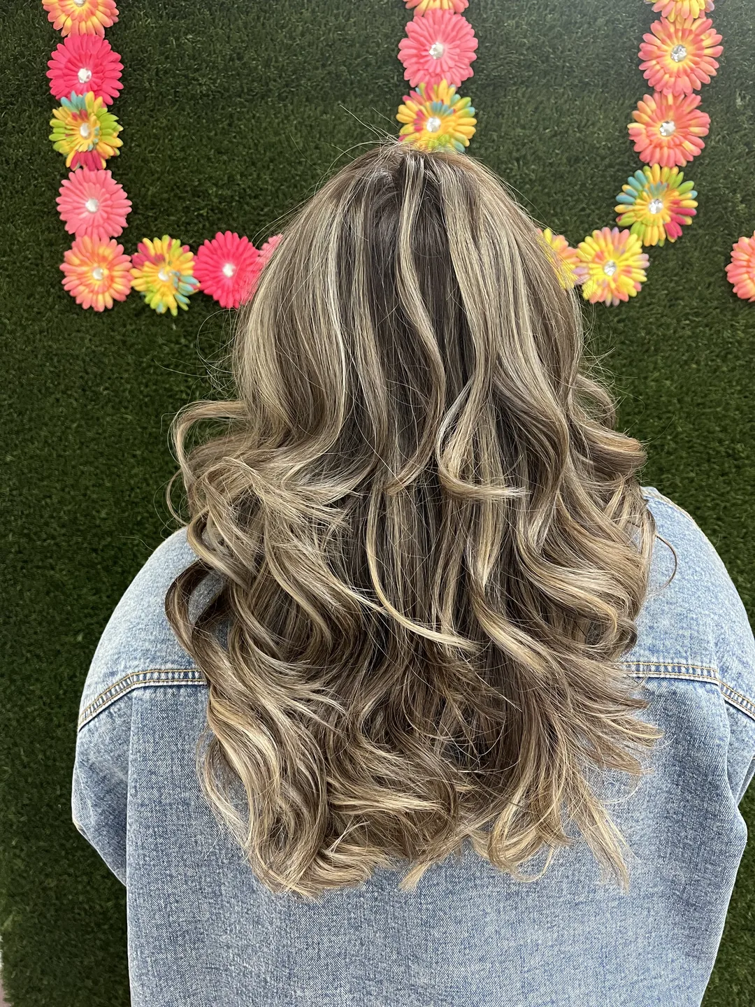 bronde balayage with denim jacket and floral wall