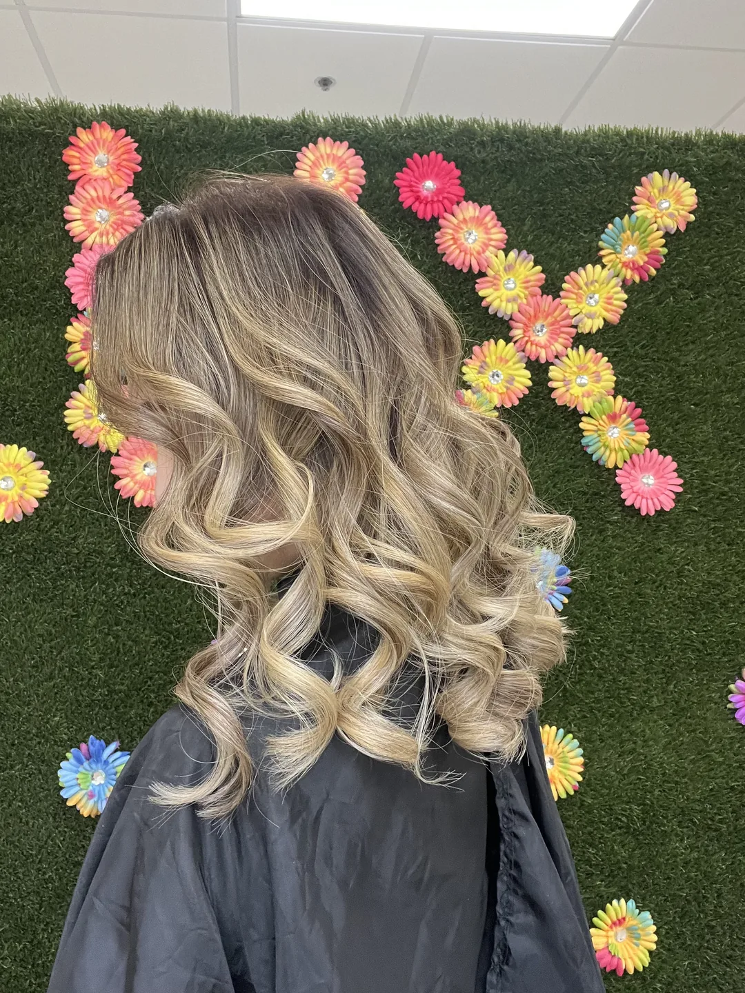 bronde balayage curls against LUX floral wall