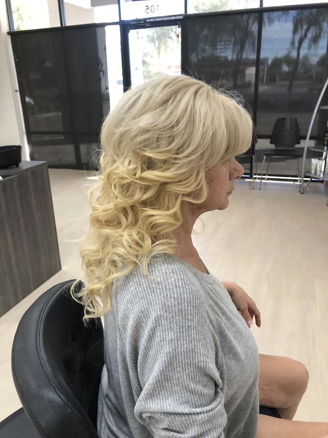 bright blonde curled half-down hairstyle salon side-view