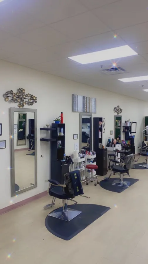Empty salon styling stations with mirrors and chairs