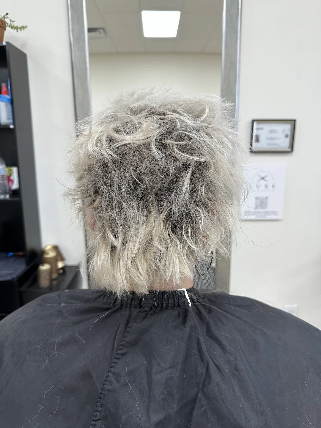 Damaged brassy blonde hair before-treatment in salon mirror